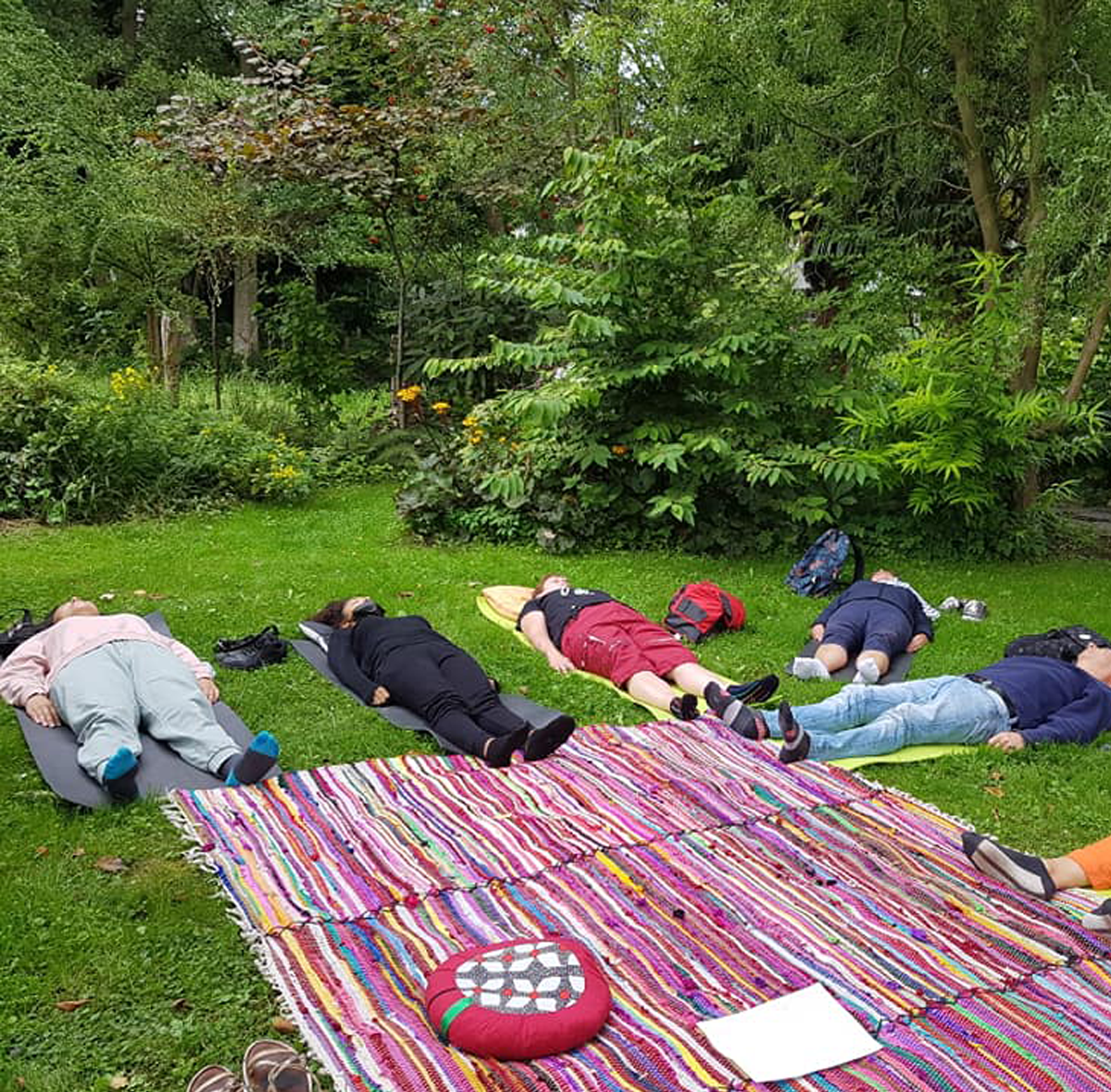 Des personnes allongées dans la forêt pour une séance de relaxation